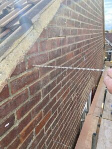 Lateral restraint ties installed to masonry during wall tie repairs in Deal